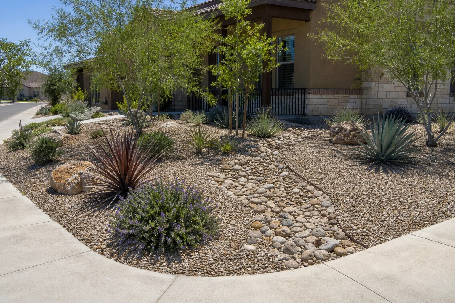 Water-wise front yard with fresh gravel and river-rock drainage swale